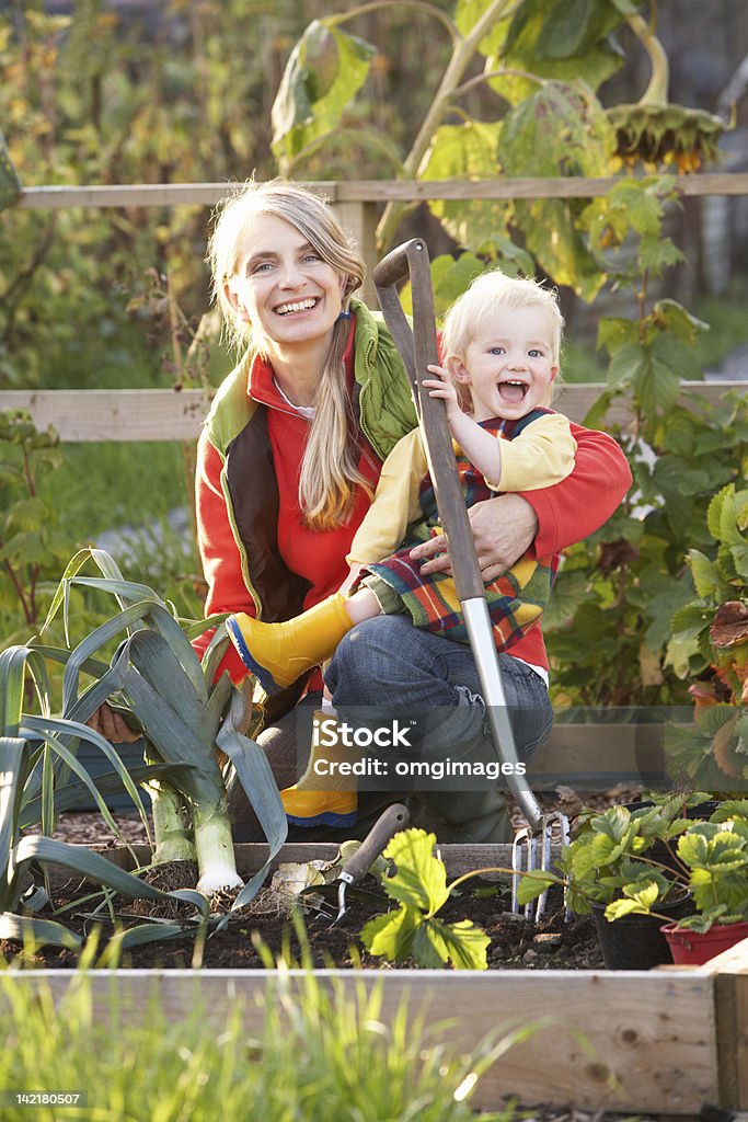 Mulher trabalhando em Alocação com criança - Foto de stock de Jardim comunitário royalty-free