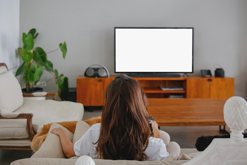 Rear view shot of indonesian woman binge watching her favourite tv show