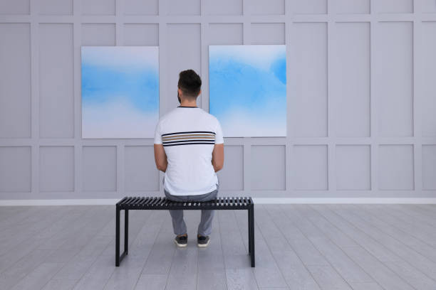 istock Man at exhibition in art gallery, back view 1421808391