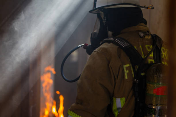 istock Firefighter in burning building, with fire and smoke 1421809240
