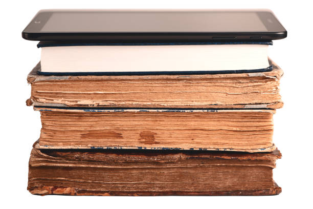 Stack of old and new books, digital tablet isolated on white. New technology concept. Choice between paper books and e-reader. Closeup