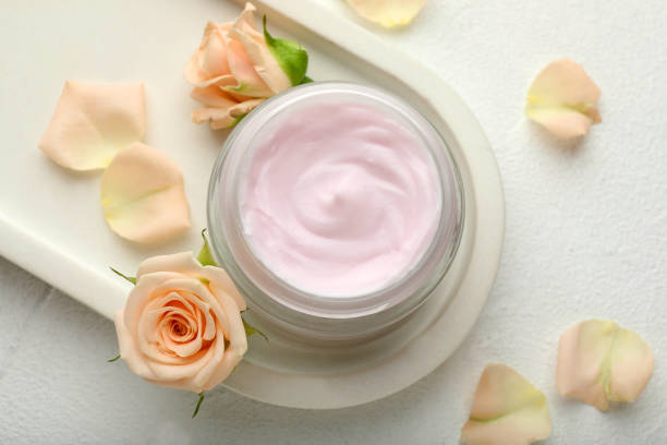 istock Jar of organic cream and roses on white table, flat lay 1421810941