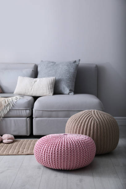 istock Stylish knitted poufs near sofa in living room. Interior element 1421812748