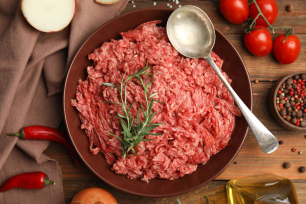 istock Fresh minced meat and other ingredients on wooden table, flat lay 1421818108