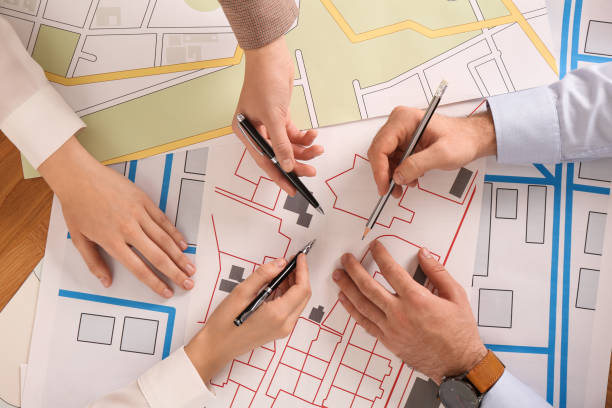 istock Professional cartographers working with cadastral map at table, top view 1421818327