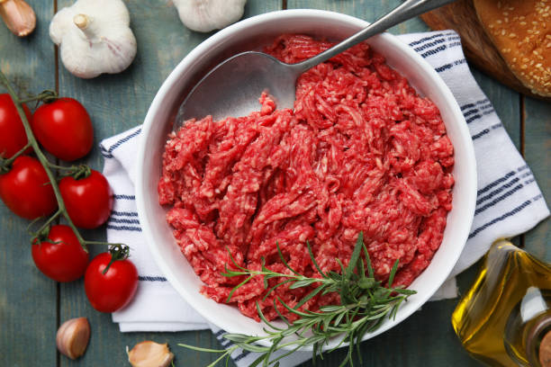 istock Fresh minced meat and other ingredients on light blue wooden table, flat lay 1421818364