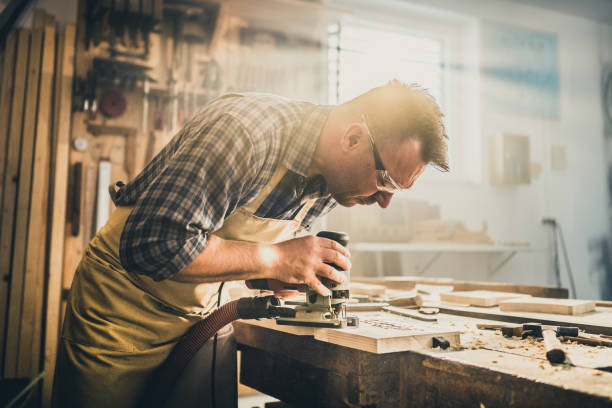 istock Mature man cutting wood in workshop 1421818949
