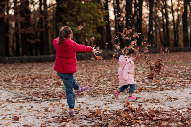 istock Girls playing in autumn park 1421821510