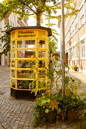 Old yellow telephone booth in Germany with text öffentlicher fernsprecher - public telephone