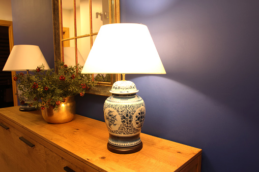 Lamp with retro-style lampshade Lamp on and placed on a low cabinet in luxury home