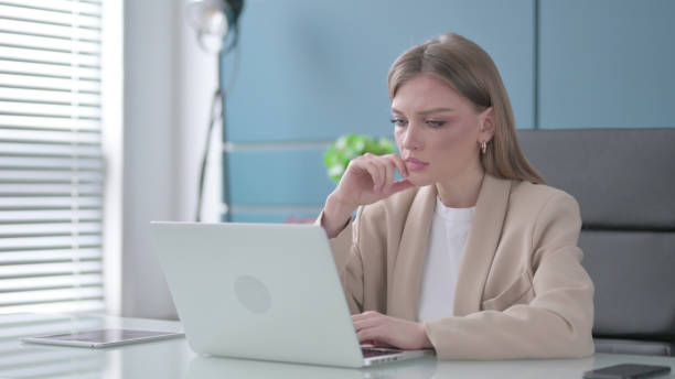 istock Businesswoman Thinking while Working on Laptop in Office 1421827626