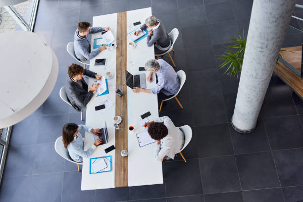 istock Above view of entrepreneurs working at conference table in the office. 1421827730