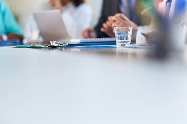 Defocused group of mature and mid adult businesswoman wearing smart casual sitting during conference meeting.