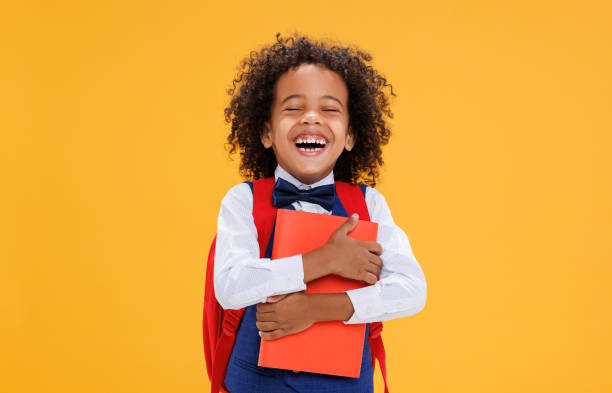 istock Happy ethnic schoolboy laughing ahd holding book 1421835554