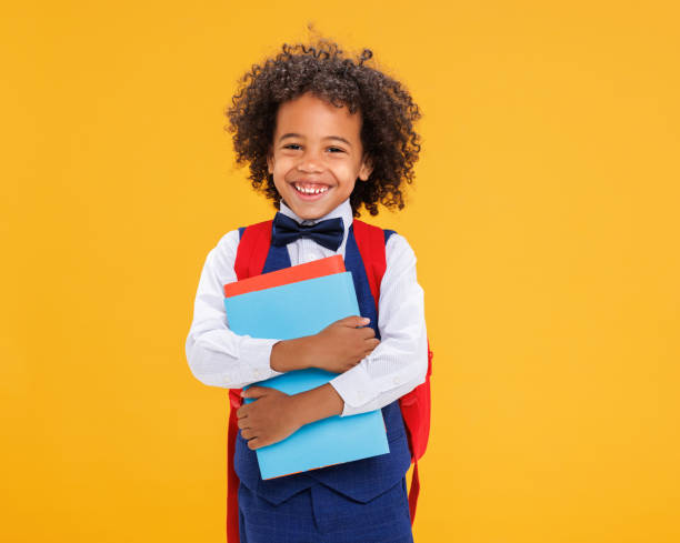 istock Happy ethnic schoolboy laughing ahd holding book 1421836094