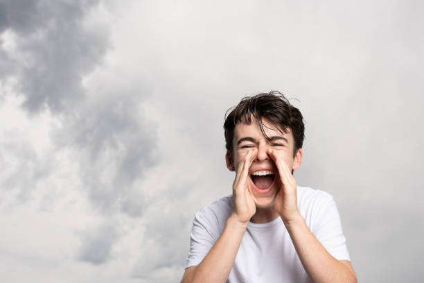 istock Teenager boy shouting under dramatic sky 1421842744