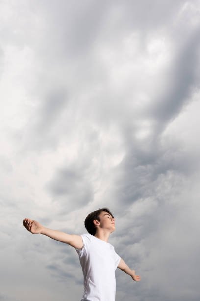 istock Teenager boy praying for rain 1421843822