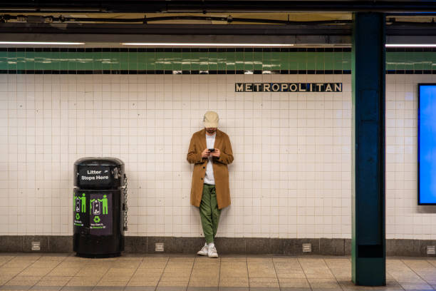 Young man with street style coat, hat, at the station on the New York Subway line without people Young man with street style coat, hat, at the station on the New York Subway line without people new york marathon photos stock pictures, royalty-free photos & images