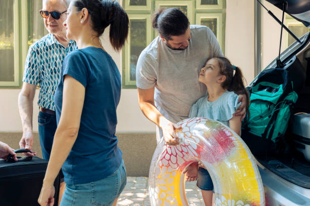 istock Parents with child loading trolley in trunk 1421845769