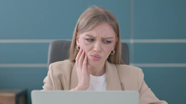 istock Close up of Businesswoman having Toothache while using Laptop 1421846036