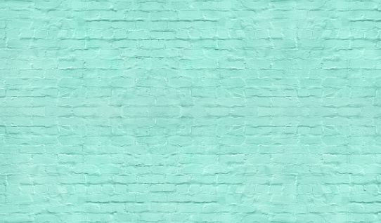 Light teal color painted old shabby brick wall texture. Pastel turquoise brickwork background