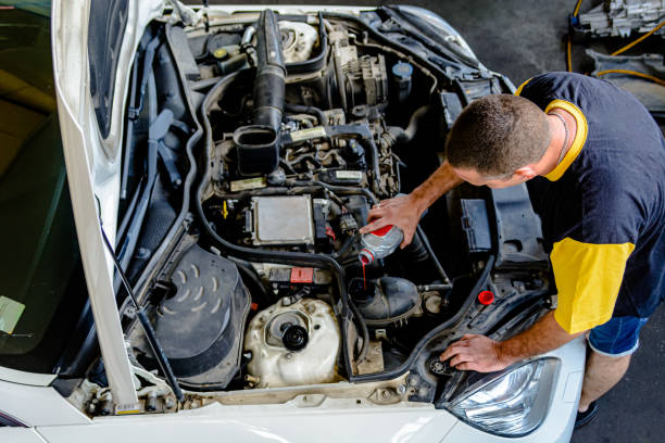 自動車整備士が車内の貯蔵タンクにクーラントを注いでいます。 - storage tank cleaning industry safety ストックフォトと画像