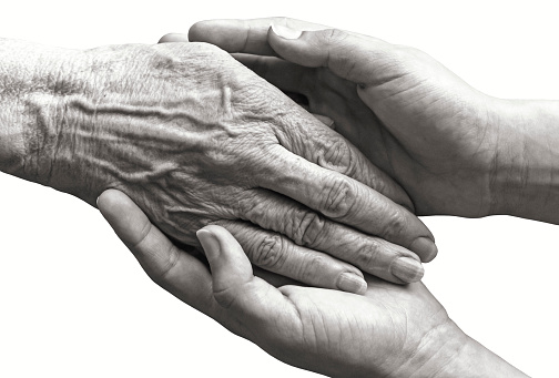 Young hands holding old woman palm, isolated closeup black and white picture