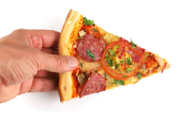 istock Sliced pizza in hand isolate. Male hand picking tasty pizza slice isolated 1421849669