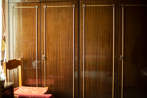 Old wardrobe in apartment. Old furniture in interior. Wooden furniture of house.