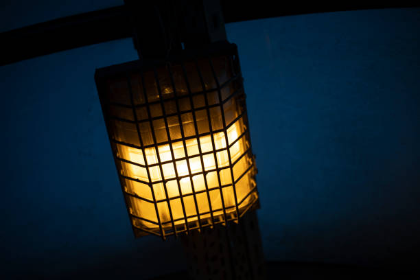 istock Lamp behind bars. Dim lamp light. Light system in tunnel. 1421851767