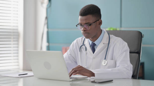 istock Young African Doctor Working on Laptop in Office 1421851933