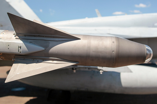 A missile head on the wing of a fighter jet.