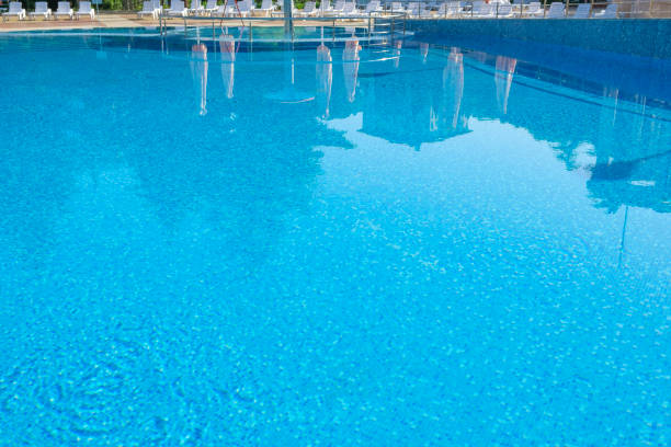istock Pool side. Empty outdoors swimming pool on summer sunny day. Seaside vacation and hotel resort concept. Reflection in blue clean sea water pool 1421852095