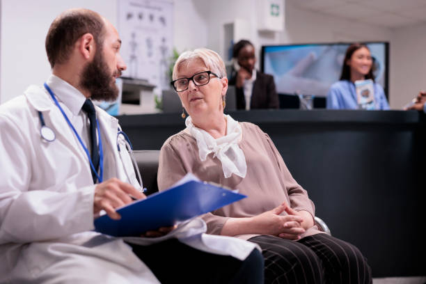 istock General practitioner consulting senior woman at reception 1421853336