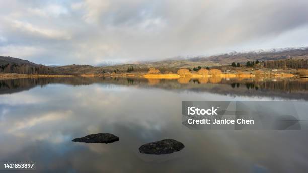 Trees On The Shore Of Butchers Dam Lit Up By Morning Sun Alexsandra Central Otago Stock Photo - Download Image Now
