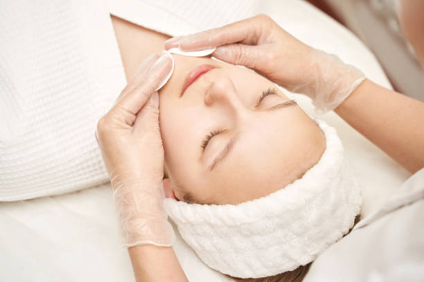 istock Face massage at luxury spa salon. Cottom pad. Remove mascara. Doctor hands 1421858771