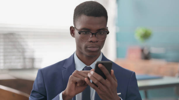 istock Young African Businessman using Smartphone 1421864134