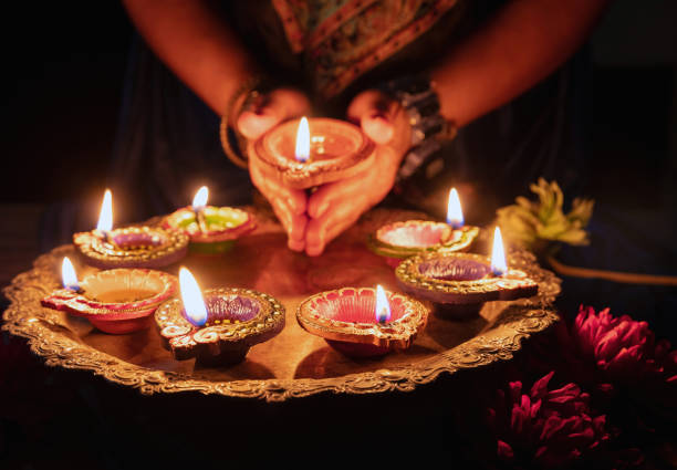 diwali festival der lichter feier. diya lampe in frauenhänden, nahaufnahme - hinduism outdoors horizontal close up stock-fotos und bilder
