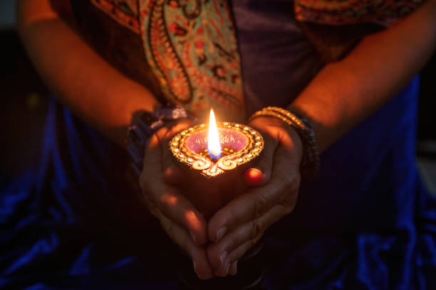 diwali festival der lichter feier. diya lampe in frauenhänden, nahaufnahme - hinduism outdoors horizontal close up stock-fotos und bilder