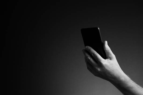 istock Hand holding smart phone, side view and copy space 1421870248