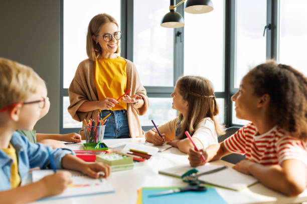 istock Teacher conducts a lesson, gives a lecture children during school work 1421872415