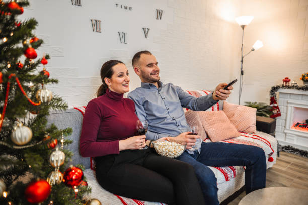 istock Happy couple enjoying on sofa, watching TV 1421876688