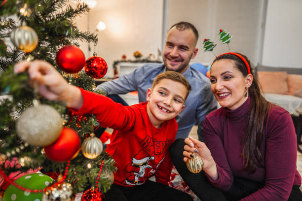 istock Family decorating a Christmas tree 1421876838