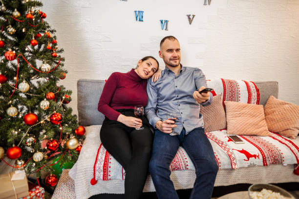 istock Happy couple enjoying on sofa, watching TV 1421876882