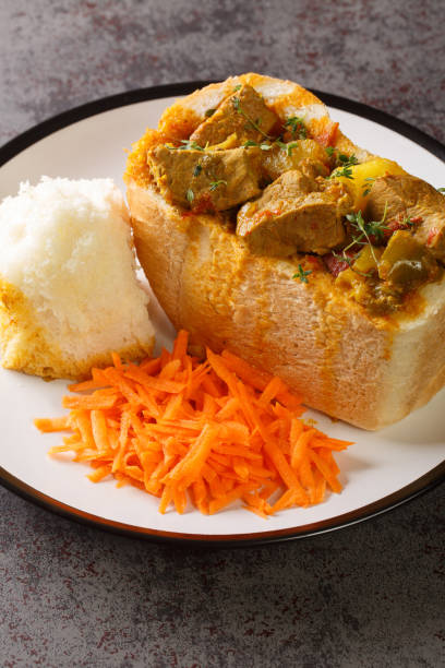 istock South African Bunny Chow bread stuffed with lamb curry with vegetables close-up on a plate. vertical 1421878812