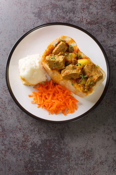 istock South African Bunny Chow bread stuffed with lamb curry with vegetables close-up on a plate. vertical top view 1421879464