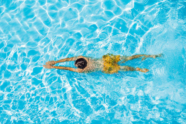 istock Young man swims in the pool, summer vacation concept 1421881721