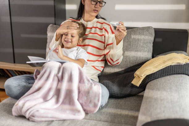 istock Mother takes daughter's temperature 1421886116
