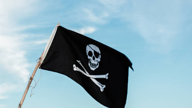 istock Pirates Flag Weaving On Blue Sky 1421887654