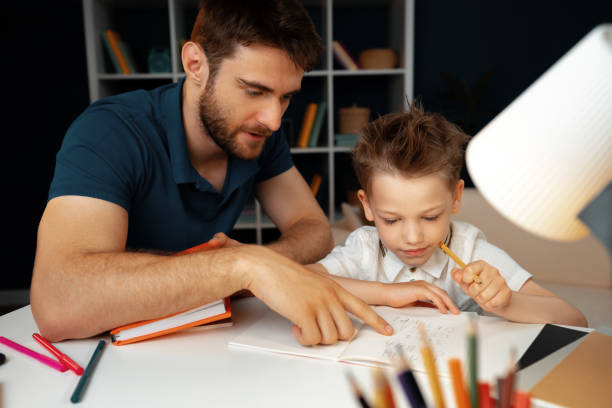 istock Father helping his little son with school homework 1421893554